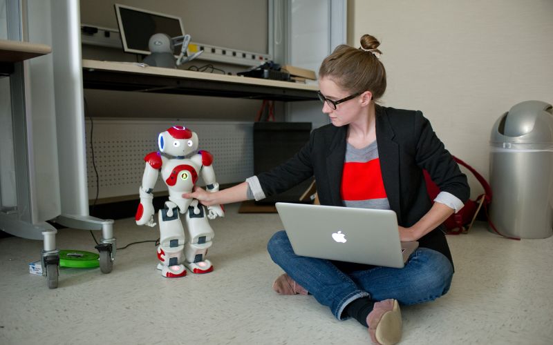 student with a robot and laptop computer